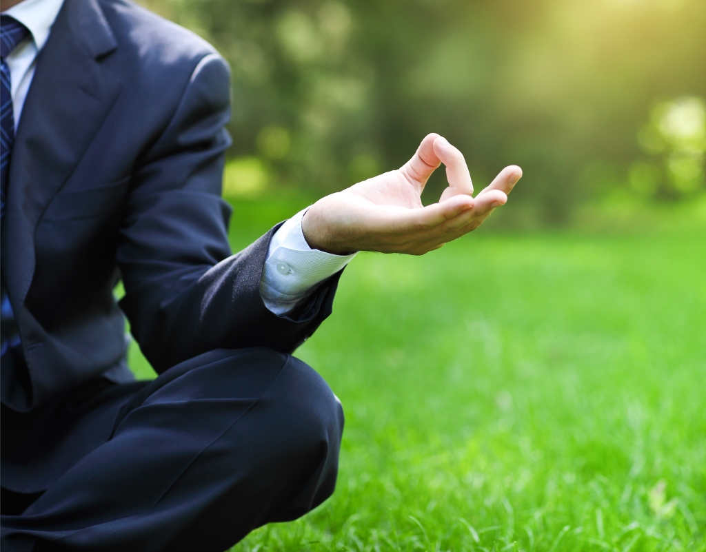 Business man relaxing in a park in the lotus position. Close up Business man relaxing in a park in the lotus position. Close up